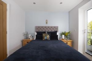 a bedroom with a large bed and a window at 5 Sandy Lane Apartments, Carbis Bay in Carbis Bay