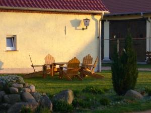two wooden chairs and a picnic table in a yard at Apartment im Fläming auch für Rollifahrer in Rietdorf +3 photos