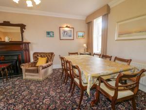 ein Esszimmer mit Tisch und Stühlen und einem Kamin in der Unterkunft The Haw Country Home in Bushmills