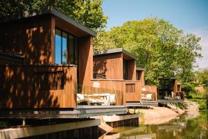 a house on the water with trees in the background at South Lodge in Lower Beeding