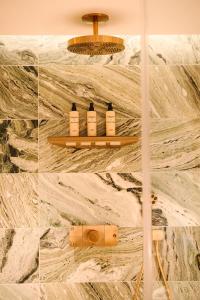 a bathroom with four bottles of soap on a wall at South Lodge in Lower Beeding