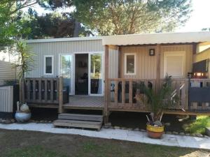a tiny house with a large deck at Le mobilhome de Maelya in Saint-Cyprien
