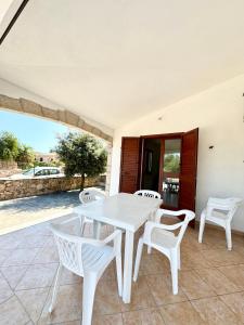 a white table and chairs on a patio at Case vacanza Corallo - San Teodoro centro in San Teodoro
