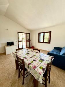 a living room with a table and a blue couch at Case vacanza Corallo - San Teodoro centro in San Teodoro