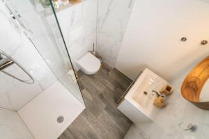 a white bathroom with a toilet and a sink at Studio Maria with Free Parking in Bohinj