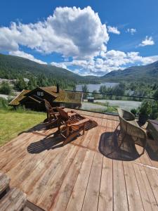 a wooden deck with a picnic table and chairs on it at Hytte Gaustablikk in Gaustablikk