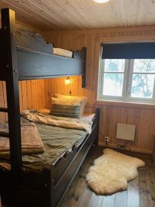 a bedroom with a bunk bed and a window at Hytte Gaustablikk in Gaustablikk
