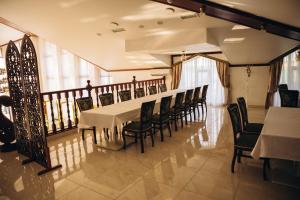 a dining room with a long table and chairs at Парк-Готель CASPIY in Zhovte