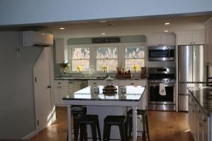 een keuken met een wit eiland met barkrukken bij Waterfront Escape Hottub, Pets Ok, Pool Table in Dennis +23 foto's