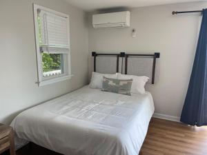 a bedroom with a large white bed with a window at Waterfront, Hottub, Petsok, Firepit, Pooltable in Dennis