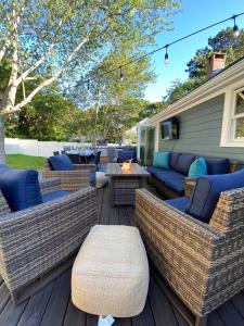 a patio with wicker furniture and a fire pit at Close2beach, Speakeasybar,hottub, Petsok, Firepit in Dennis