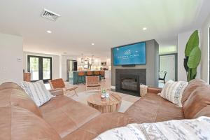 a living room with a couch and a tv at Bayside Oasis with Hot Tub & Game Room in Dennis