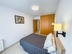 een slaapkamer met een blauw bed in een kamer bij Apartamento Marina Roses 2 in Roses