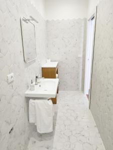 a white bathroom with a sink and a mirror at B&B Nonna Maria in Termoli