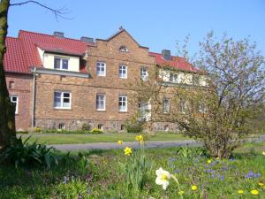 a large brick building with flowers in front of it at Apartment im Fläming auch für Rollifahrer in Rietdorf