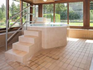 a building with a hot tub in a room with windows at Apartment Terrasse Des Alpes 3008 by Interhome in Vermala