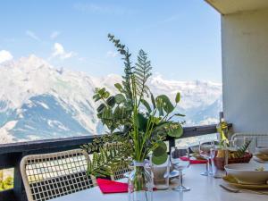 a table with a vase with a plant on it at Apartment Chaedoz 43 by Interhome in Nendaz