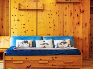 a blue couch in a room with a wooden wall at Apartment Chaedoz 43 by Interhome in Nendaz