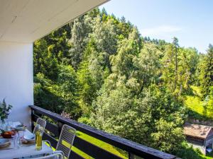 a balcony with a table and a view of a forest at Apartment Chaedoz 43 by Interhome in Nendaz