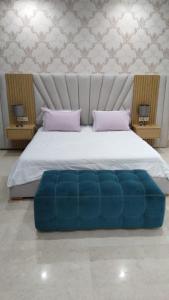 un grande letto con ottomana blu in una camera da letto di Villa mazagan golf and beach resort a Azemmour Altre 26 foto