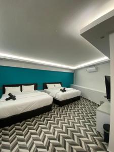 a room with two beds and a television in it at HOTEL HOMESTAY MACHANG D Sega in Machang