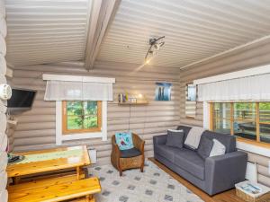 uma sala de estar com um sofá e uma mesa em Holiday Home Tarvastupa by Interhome em Kemijärvi