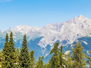 un gruppo di alberi con montagne sullo sfondo di Apartment Ambassador II Apt 13 by Interhome a Nendaz