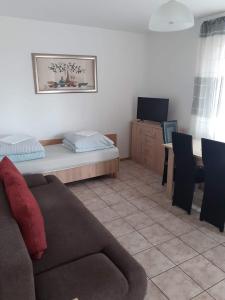a living room with a couch and a table at W Sosnach E in Dziwnówek