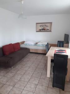 a living room with a couch and a table at W Sosnach E in Dziwnówek