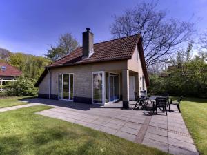 a small house with a patio in the yard at Holiday Home 4-persoons by Interhome in Dalfsen