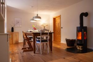 a dining room with a table and a wood stove at Landhaus mit Garten & Kamin, für Familien & Freunde in Häven