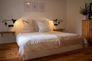a bedroom with a bed with white sheets and pillows at Landhaus mit Garten & Kamin, für Familien & Freunde in Häven +25 photos