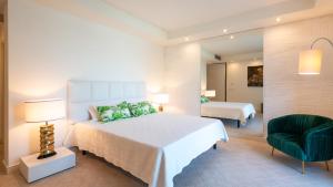 a bedroom with a bed and a chair and a mirror at VILLA BIANCA 10, Emma Villas in Misano Adriatico +37 photos