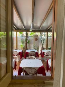 a room with tables and chairs and a window at Albergo Bouganville in Favignana