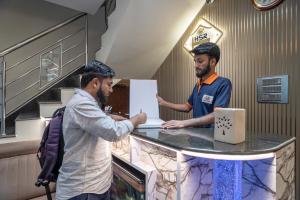 Dos hombres de pie en un mostrador de una tienda en Hotel Subha Residency Bangalore, en Bangalore