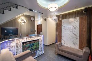 Una sala de espera con chimenea y televisión. en Hotel Subha Residency Bangalore, en Bangalore