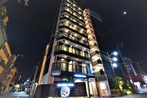 a tall building with a sign in front of it at ENKA NAMBA 1 HOTEL in Osaka