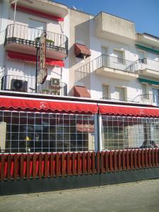 un edificio con un tendone rosso di fronte a un edificio di Hostal Calderón de la Barca a Zalamea de la Serena