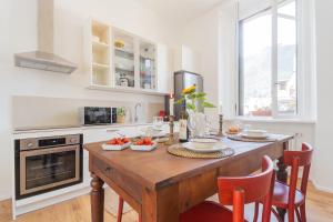cocina con mesa de madera y sillas rojas en Rooftop Nest in Como city center by Rent All Como, en Como 45 fotos más