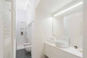 Un baño blanco con dos lavabos y un espejo. en Rooftop Nest in Como city center by Rent All Como, en Como