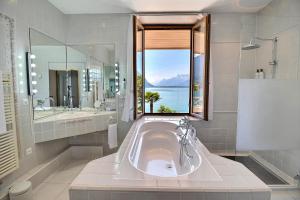 a bathroom with a tub and a large window at La Villa in Montreux