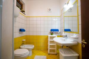 a yellow and white bathroom with two toilets and a sink at Casa Fiore in Torre Marino