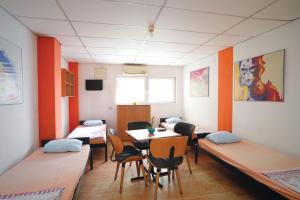 a room with beds and a table and chairs at HILJADNIKOV Apartments in Štip