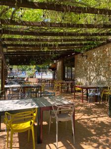 a patio with tables and chairs under a pergola at Hotel Il Pietreto in Colle di Val d'Elsa