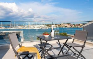 ein Tisch und Stühle auf einem Balkon mit Blick auf das Wasser in der Unterkunft Amazing Apartment In Betina in Betina