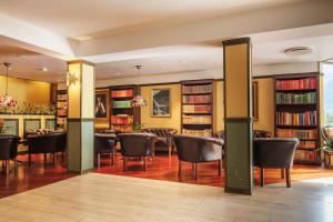 a dining room with a table and chairs and books at Olden Fjordhotel in Olden