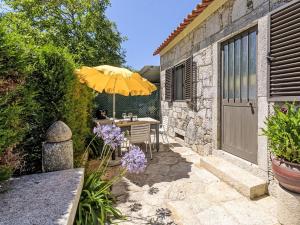 a patio with a table and an umbrella at Holiday Home Do Condado by Interhome in Caminha