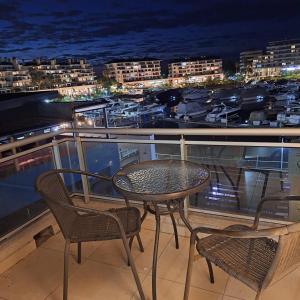 ベナビデスにあるdepartamento en Nordelta condo 216 2 amb bahia de Nordeltaの港の景色を望むバルコニー(テーブル、椅子付)