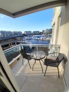 ベナビデスにあるdepartamento en Nordelta condo 216 2 amb bahia de Nordeltaの港の景色を望むバルコニー(テーブル、椅子付)