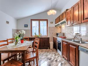 kuchnia z drewnianymi szafkami i stołem oraz jadalnia w obiekcie Holiday Home Jakov by Interhome w mieście Žminj